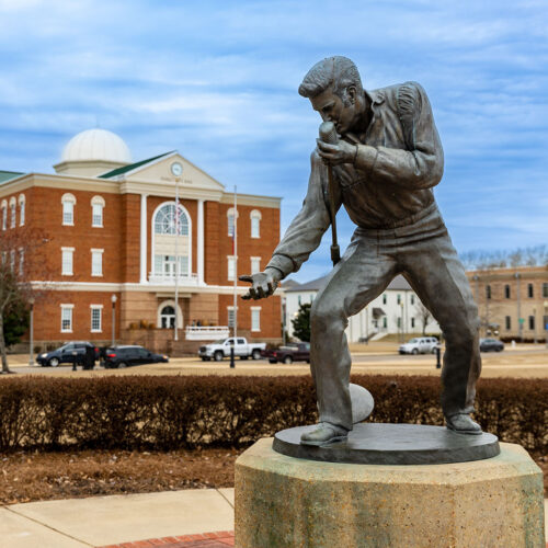 Tupelo, MS: Elvis Presley-Statue in Tupelo, MS, mit dem Rathaus im Hintergrund